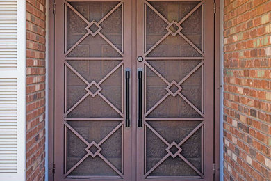 Example of a large classic brick floor entryway design in Austin with brown walls and a brown front door