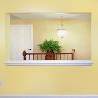 Inspiration för klassiska hallar, med gula väggar och mörkt trägolv