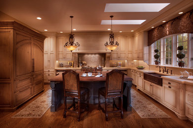 Large elegant u-shaped medium tone wood floor and brown floor open concept kitchen photo in Other with a farmhouse sink, raised-panel cabinets, beige cabinets, quartz countertops, beige backsplash, stone tile backsplash, paneled appliances and an island