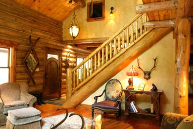 Large mountain style open concept medium tone wood floor living room photo in Other with brown walls, a wood stove and no tv