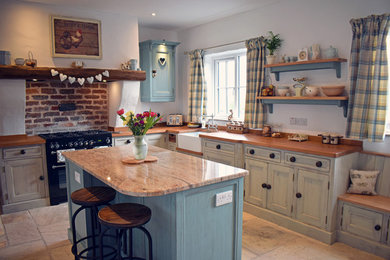 This is an example of a country u-shaped open plan kitchen in Belfast with with island, a farmhouse sink, beaded inset cabinets, distressed cabinets, brick splashback and panelled appliances.