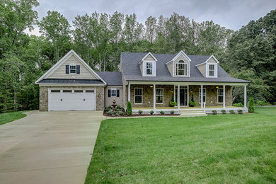 Example of a mid-sized classic beige one-story stone exterior home design in Other with a shingle roof