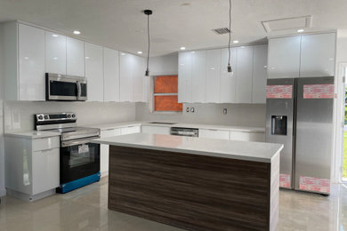 Inspiration for a contemporary ceramic tile and brown floor eat-in kitchen remodel in Miami with an undermount sink, stainless steel appliances and an island