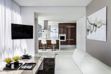 This is an example of a small contemporary enclosed living room in Miami with grey walls, a wall-mounted tv and white floor.