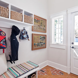 シャーロットの小さい片開きドアトランジショナルスタイルのおしゃれなマッドルーム (グレーの壁、レンガの床、白いドア、赤い床) の写真