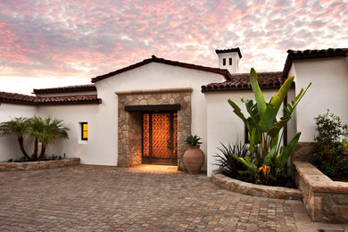 Inspiration for a mediterranean one-storey stucco white house exterior in Santa Barbara with a gable roof and a tile roof.