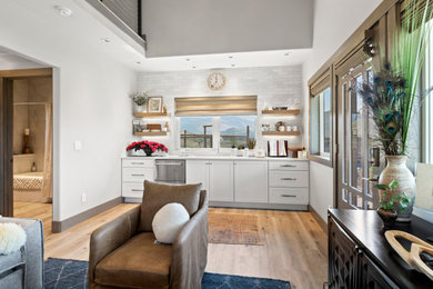 Home bar - small eclectic light wood floor and brown floor home bar idea in Other with an undermount sink, shaker cabinets, white cabinets, quartz countertops, white backsplash and white countertops