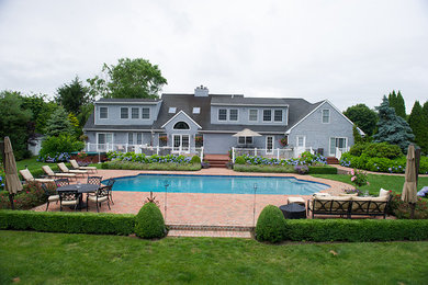 Inspiration for a large traditional full sun backyard brick landscaping in New York.