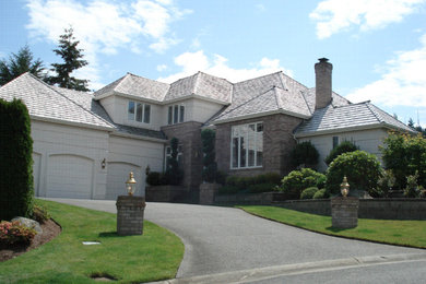 Modelo de fachada beige contemporánea grande de dos plantas con revestimientos combinados y tejado a doble faldón