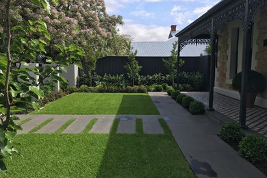 This is an example of a mid-sized contemporary front yard partial sun formal garden for spring in Adelaide with natural stone pavers.