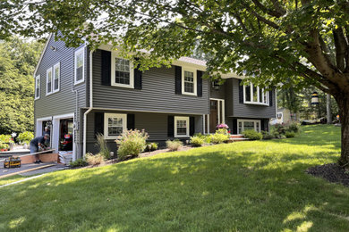 Mittelgroßes, Einstöckiges Klassisches Einfamilienhaus mit Vinylfassade, blauer Fassadenfarbe, Pultdach, Schindeldach, schwarzem Dach und Verschalung in Boston