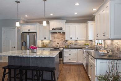 Example of a mid-sized trendy l-shaped medium tone wood floor eat-in kitchen design in Boston with a farmhouse sink, shaker cabinets, white cabinets, granite countertops, multicolored backsplash, porcelain backsplash, stainless steel appliances and an island