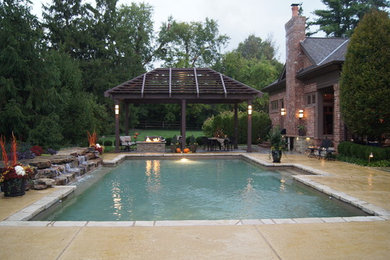 Large traditional backyard rectangular pool in San Diego with a water feature and stamped concrete.