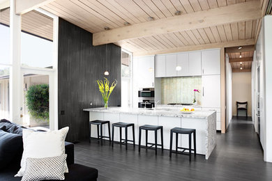 Example of a 1960s kitchen design in Santa Barbara with flat-panel cabinets, white cabinets, metallic backsplash and stainless steel appliances