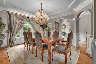Inspiration for a timeless medium tone wood floor enclosed dining room remodel in Other with gray walls