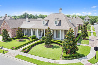 Mid-sized traditional beige one-story stone exterior home idea in New Orleans