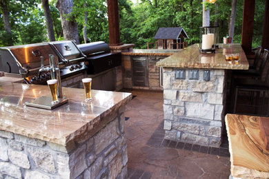 Large mountain style backyard concrete paver patio kitchen photo with a gazebo