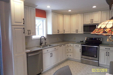 Large transitional l-shaped vinyl floor and beige floor eat-in kitchen photo in Louisville with an undermount sink, raised-panel cabinets, beige cabinets, quartz countertops, white backsplash, ceramic backsplash, stainless steel appliances, no island and multicolored countertops