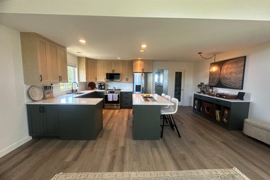 Example of a mid-sized laminate floor kitchen design in Other with shaker cabinets, light wood cabinets, quartzite countertops, white backsplash, subway tile backsplash, stainless steel appliances, two islands and white countertops