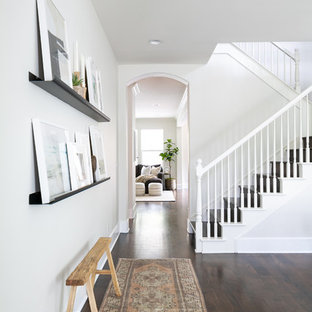 Exempel på en maritim hall, med vita väggar, mörkt trägolv och brunt golv