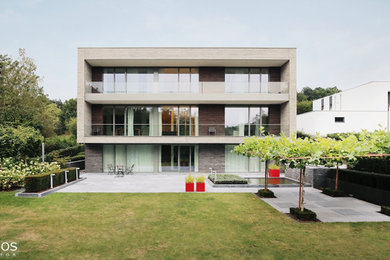 Photo of a large and multi-coloured contemporary two floor detached house in Other with wood cladding and a flat roof.