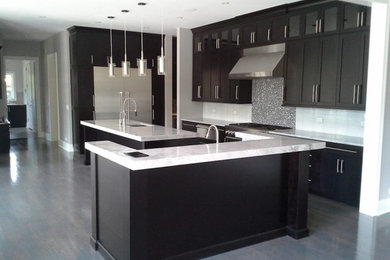 Eat-in kitchen - large transitional u-shaped light wood floor and gray floor eat-in kitchen idea in Chicago with an undermount sink, recessed-panel cabinets, black cabinets, quartz countertops, white backsplash, ceramic backsplash, stainless steel appliances, two islands and white countertops