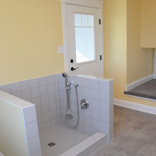 ワシントンD.C.の大きいトランジショナルスタイルのおしゃれな洗濯室 (アンダーカウンターシンク、グレーのキャビネット、ラミネートカウンター、黄色い壁、セラミックタイルの床、左右配置の洗濯機・乾燥機、茶色い床) の写真