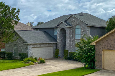 Mid-sized two-story exterior home photo in Austin with a shingle roof and a gray roof