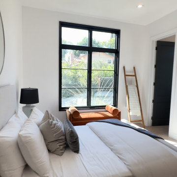Bedroom with Round Mirror and Layered Neutral Bedding - Studio City
