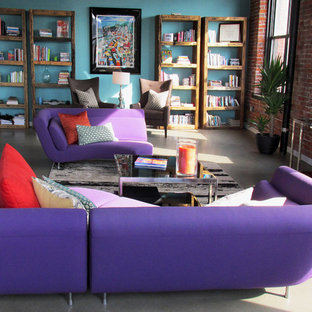 Idee per un grande soggiorno design stile loft con libreria, pareti blu, pavimento in cemento e TV autoportante