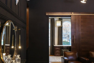 Inspiration for a mid-sized transitional light wood floor home bar remodel in Other with dark wood cabinets, quartz countertops and black countertops