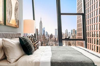 Photo of a mid-sized scandinavian guest bedroom in New York with green walls, medium hardwood floors, no fireplace and grey floor.