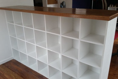 Inspiration for a small timeless light wood floor and beige floor mudroom remodel in Chicago with white walls