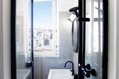 Ejemplo de cuarto de baño urbano con ducha esquinera, sanitario de pared, baldosas y/o azulejos blancas y negros y baldosas y/o azulejos de mármol