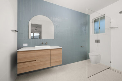 Design ideas for a mid-sized modern 3/4 bathroom in Brisbane with medium wood cabinets, blue tile, white walls, engineered quartz benchtops, white benchtops, a single vanity and a floating vanity.