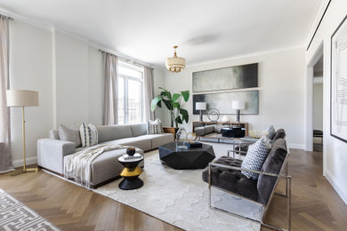 Example of a trendy medium tone wood floor and brown floor living room design in New York with white walls