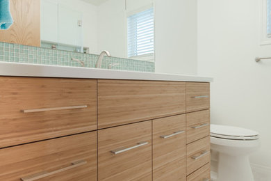 Bathroom - mid-sized modern 3/4 green tile and glass tile porcelain tile and gray floor bathroom idea in Calgary with flat-panel cabinets, light wood cabinets, a two-piece toilet, gray walls, an undermount sink and quartz countertops