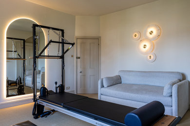 Inspiration for a medium sized contemporary home yoga studio in London with carpet, beige floors, a vaulted ceiling and feature lighting.