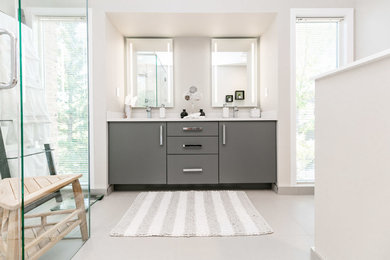 Example of a minimalist master white tile ceramic tile walk-in shower design in Calgary with flat-panel cabinets, gray cabinets, an undermount sink, quartz countertops and a hinged shower door