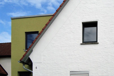 Mittelgroßes, Zweistöckiges Klassisches Einfamilienhaus mit gestrichenen Ziegeln, weißer Fassadenfarbe, Satteldach, Ziegeldach, rotem Dach und Dachgaube in Nürnberg