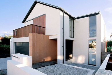 Photo of a large contemporary two-storey brick white house exterior in Sydney with a gable roof and a tile roof.