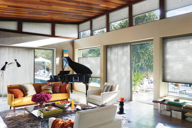 Example of a mid-century modern concrete floor and gray floor living room design in Sacramento with a music area, beige walls and no fireplace