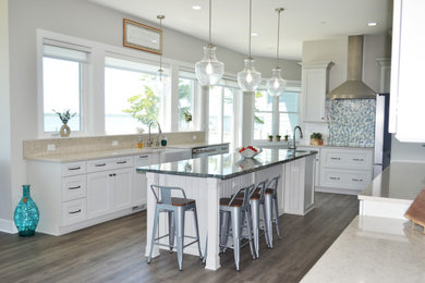 Kitchen - mid-sized coastal brown floor kitchen idea in Other with shaker cabinets, white cabinets, quartzite countertops, mosaic tile backsplash and an island