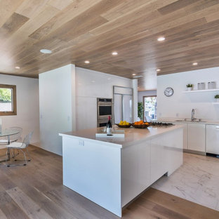 Mittelgroße Retro Küche in L-Form mit Vorratsschrank, flächenbündigen Schrankfronten, weißen Schränken, Küchenrückwand in Weiß, Kücheninsel, weißem Boden und weißer Arbeitsplatte in Los Angeles