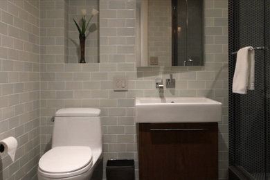 Mid-sized trendy master blue tile and ceramic tile mosaic tile floor alcove shower photo in New York with a wall-mount sink, flat-panel cabinets, dark wood cabinets, a one-piece toilet and blue walls