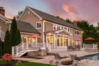 Large elegant brown two-story wood exterior home photo in New York with a shingle roof