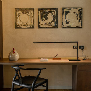 Ispirazione per una stanza da lavoro minimal con pareti beige, parquet chiaro, scrivania autoportante e pavimento marrone