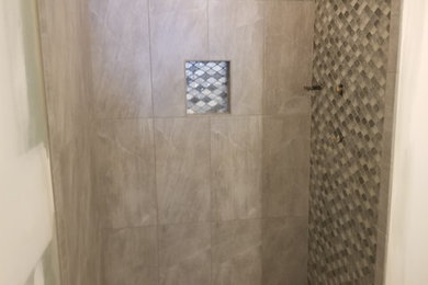 Small minimalist 3/4 gray tile and mosaic tile porcelain tile and gray floor bathroom photo in New York with shaker cabinets, gray cabinets, a one-piece toilet, gray walls, a vessel sink and quartz countertops