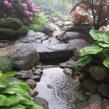 Waterfalls pond and stream with stone bridge