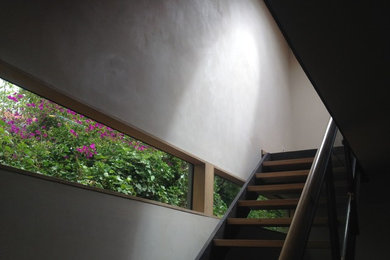 Foto de escalera suspendida moderna con escalones de madera y contrahuellas de metal